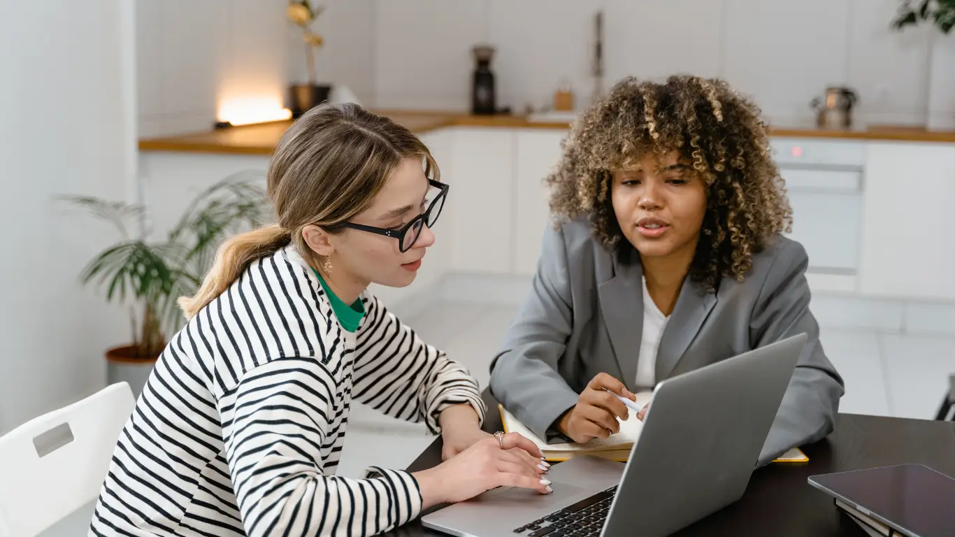 Action coach image of two work mates discussing and working together